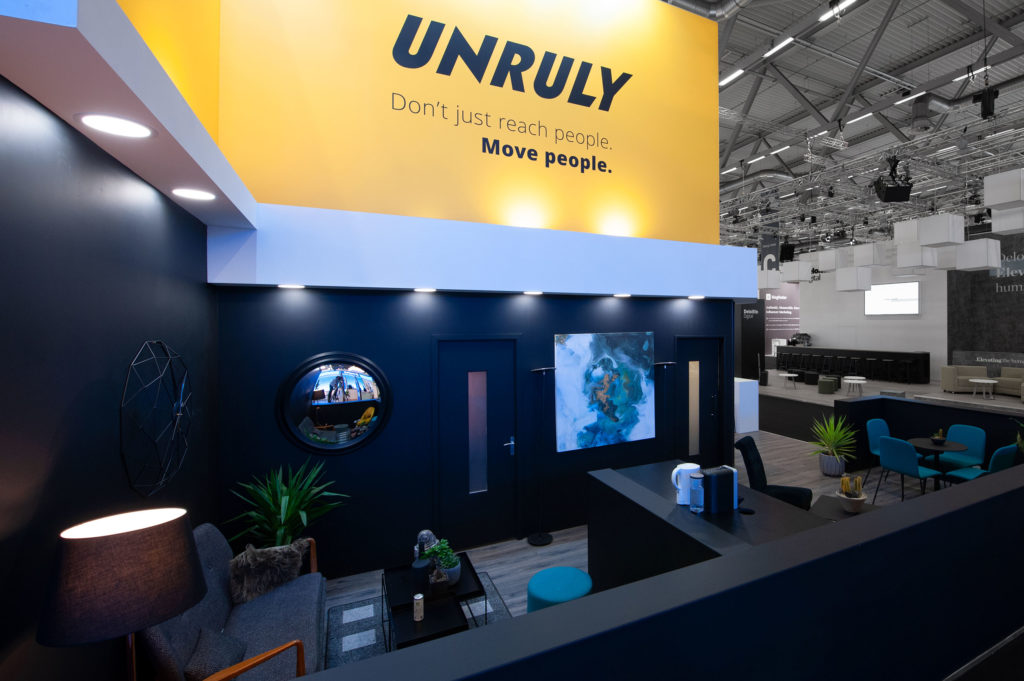 Unruly exhibition stand, sideview, showing meeting pods and custom branding 