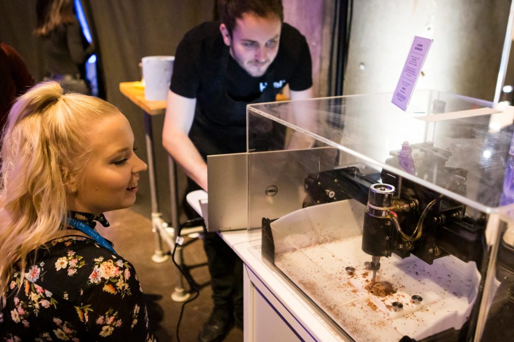 3D chocolate printer experience with female conference guest looking on