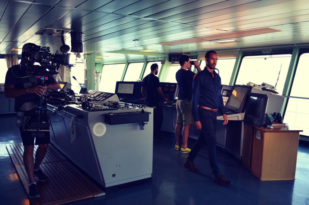 film crew and actor in naval ship bridge, shooting Inmarsat 40th Anniversary communications film