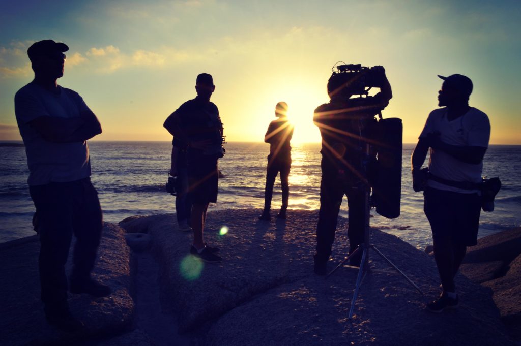 Silhouetted film crew in front of ocean, onsite making Inmarsat 40th Anniversary communications film